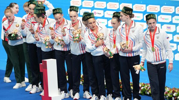 The Russian team (Anastasia Bakhtyreva, Tatyana Gaidai, Daria Geloshvili, Yekaterina Kossova, Varvara Kreopalova, Elizaveta Minaeva, Elizaveta Smirnova, Agnia Tulupova, Anna Andrianova, Maya Doroshko, Evelina Simonova, Veronika Sokolova) at the awarding ceremony after winning 1st place in the acrobatic group at the BRICS Synchronized Swimming Games in Kazan. - Sputnik International