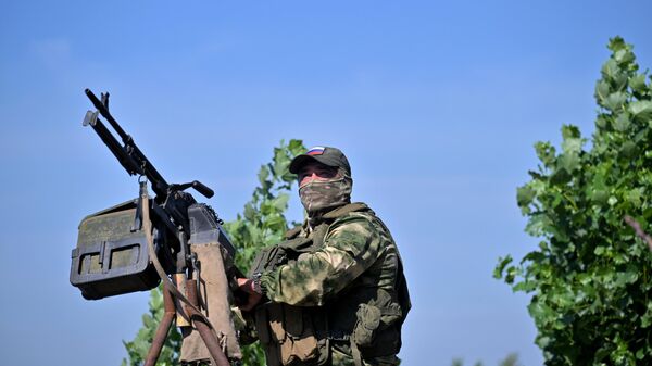 A Russian serviceman of the Central military district prepares to fire a machine gun - Sputnik International