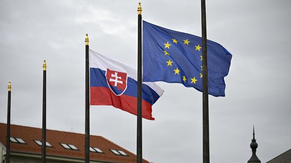 The Slovak national flag, left, flutters next to the flag of European Union in front of the Presidential Palace in Bratislava, Slovakia on Friday, April 5, 2024 - Sputnik International