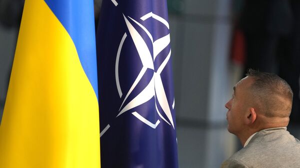 A member of protocol sets up the NATO and Ukrainian flags in Brussels, Wednesday, Oct. 11, 2023. - Sputnik International