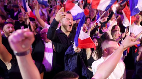 Supporters react as former president of the French right-wing Rassemblement National (RN) parliamentary group Marine Le Pen gives a speech during the results evening of the first round of the parliamentary elections in Henin-Beaumont, northern France, on June 30, 2024. - Sputnik International
