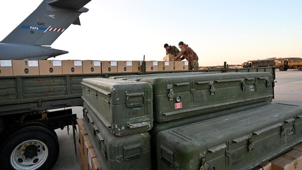 Ukraine's servicemen load a flat bed truck with boxes as US made FIM-92 Stinger missiles (Front) and a man-portable air-defence system (MANPADS) are stacked after being shipped in to Boryspil Airport in Kiev on February 13, 2022. - Sputnik International