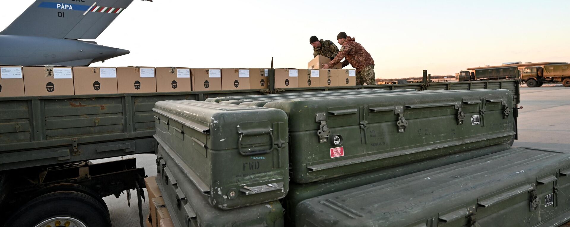 Ukraine's servicemen load a flat bed truck with boxes as US made FIM-92 Stinger missiles (Front) and a man-portable air-defence system (MANPADS) are stacked after being shipped in to Boryspil Airport in Kiev on February 13, 2022. - Sputnik International, 1920, 02.07.2024