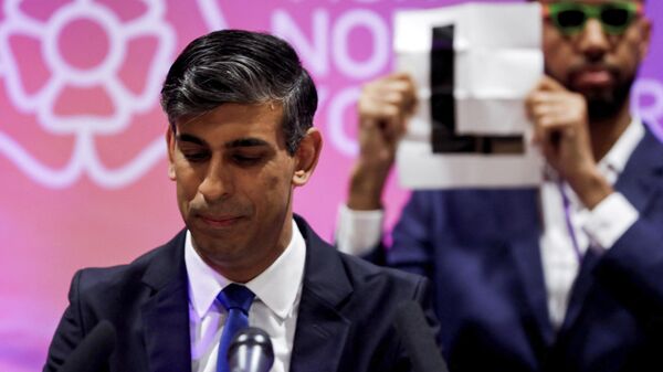 Independent candidate Niko Omilana holds an L behind Britain's Prime Minister Rishi Sunak who speaks after winning his seat in the general election at the Richmond and Northallerton count center in Northallerton, England - Sputnik International