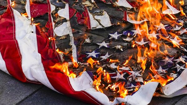 An American flag is burned as protesters gather during a march and rally for Jayland Walker, Wednesday, July 6, 2022, in New York - Sputnik International