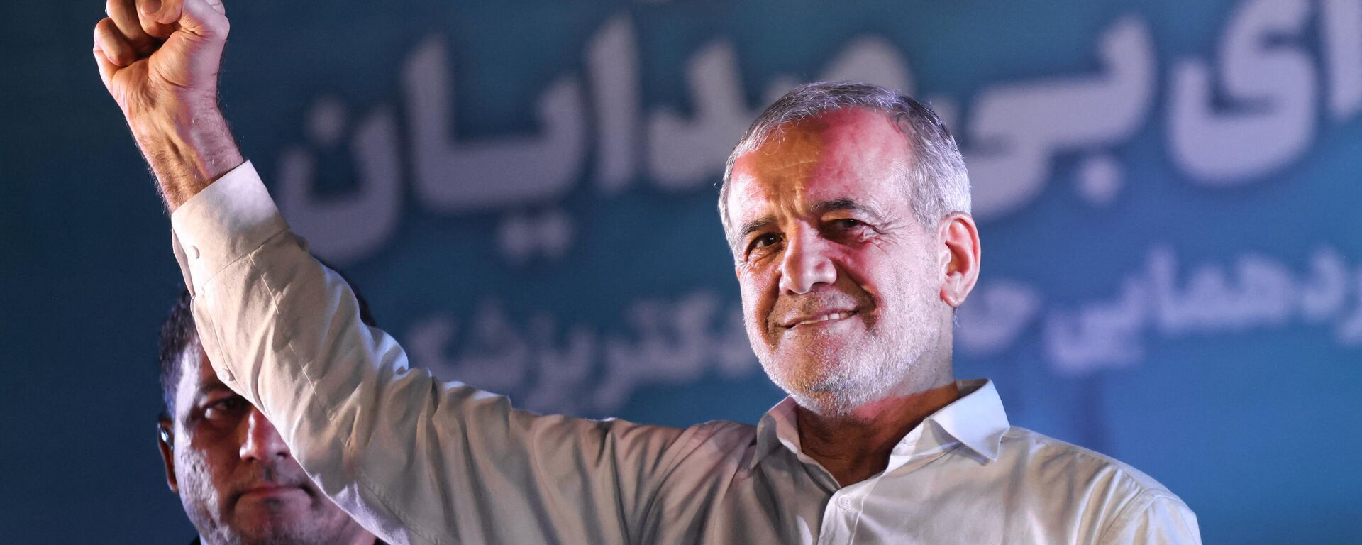 Iranian reformist candidate Masoud Pezeshkian raises his fist as he arrives for his campaign rally at a stadium in Tehran on July 3, 2024. - Sputnik International, 1920, 06.07.2024