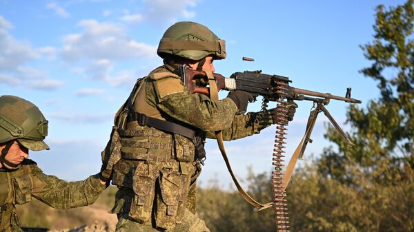 A Russian serviceman shoots a machine gun - Sputnik International