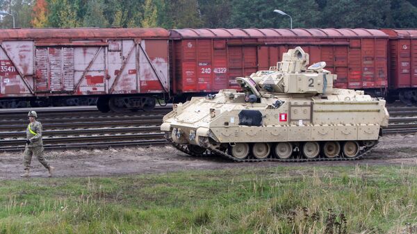 Members of the US Army 1st Brigade, 1st Cavalry Division, unload Bradley Fighting Vehicles at the railway station near the Rukla military base  - Sputnik International