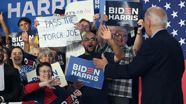 A supporter of US President Joe Biden holds a sign that read Pass the torch Joe during a campaign event in Madison, Wisconsin, on July 5, 2024.  - Sputnik International