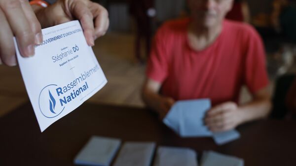 A polling station assistant holds a ballot paper during the second round of the legislative elections - Sputnik International