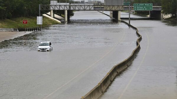 A vehicle is stranded in high waters on a flooded highway at I10 and Washington in Houston, on Monday, July 8, 2024, after Beryl came ashore in Texas as a hurricane and dumped heavy rains downtown. (AP Photo/Maria Lysaker) - Sputnik International
