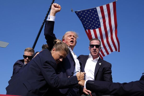 Trump leaves the stage surrounded by security. With his ear bleeding, he shouts to the crowd: &quot;Fight!&quot; - Sputnik International