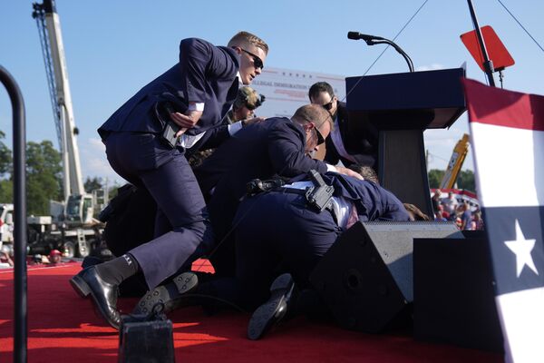 Trump is covered by Secret Service agents at the campaign rally.  - Sputnik International