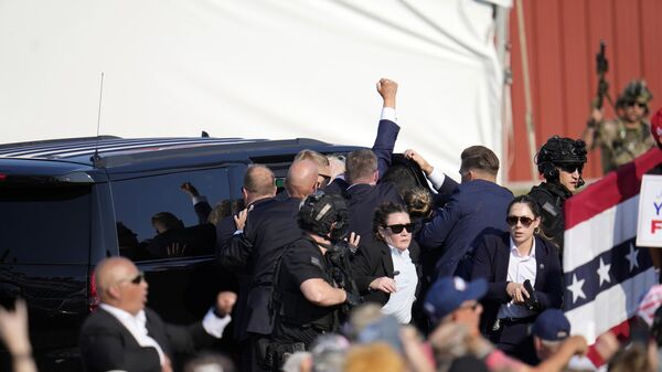 Donald Trump is led into a car after an assassination attempt at a campaign rally in Butler, USA. - Sputnik International