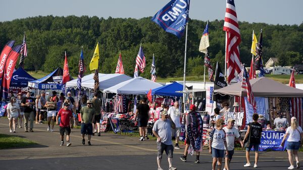 Attendees walk past merchandise at a campaign event for Republican presidential candidate former President Donald Trump in Butler, Pa., on Saturday, July 13, 2024 - Sputnik International