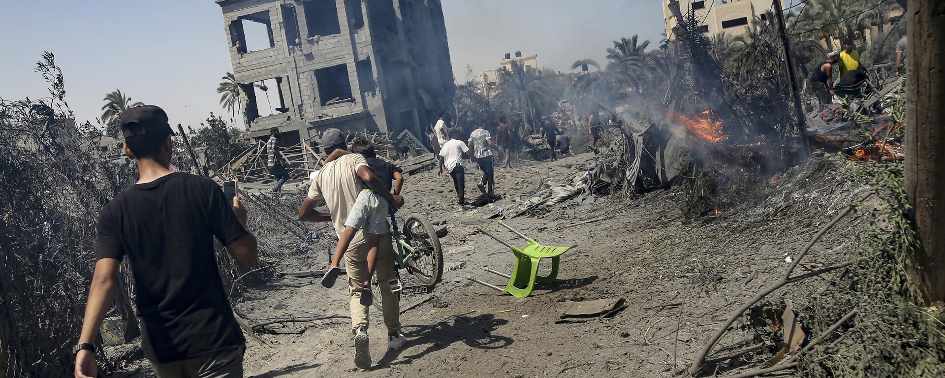 Palestinians evacuate from a site hit by an Israeli bombardment on Khan Younis, southern Gaza Strip, Saturday, July 13, 2024 - Sputnik International, 1920, 19.08.2024