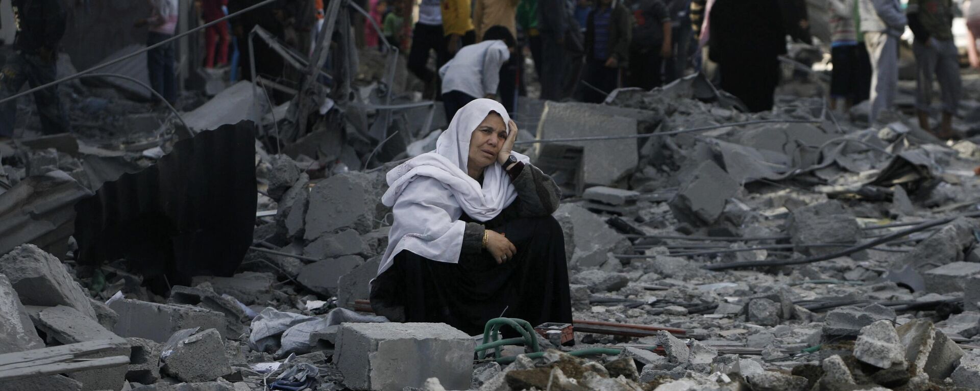 A Palestinian woman sits in rubble following an Israeli air strike in Rafah refugee camp in southern Gaza Strip, Sunday, Nov. 18, 2012. - Sputnik International, 1920, 12.08.2024