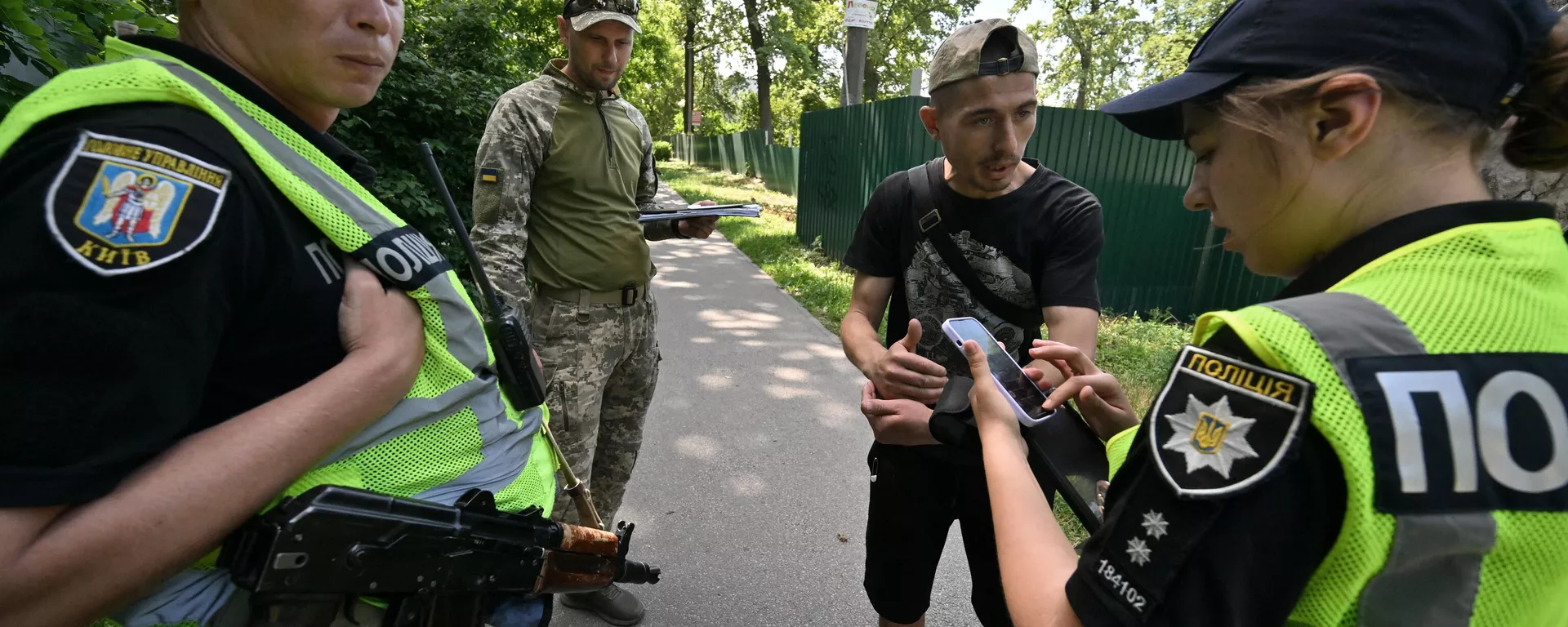 Ukrainian servicemen and police officers carry out spot checks on the papers of fighting-aged men and hand out army summons in Kiev on June 7, 2024.  - Sputnik International, 1920, 18.07.2024