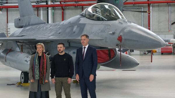 (From L) Belgium's Defense Minister Ludivine Dedonder, Ukraine's Volodymyr Zelensky, and Belgium's Prime Minister Alexander De Croo pose for a photograph next to an F-16 fighter jet during an inspection visit of Ukraine's president to Belgium at the Melsbroek military airport in Steenokkerzeel, north-east of Brussels on May 28, 2024.  - Sputnik International