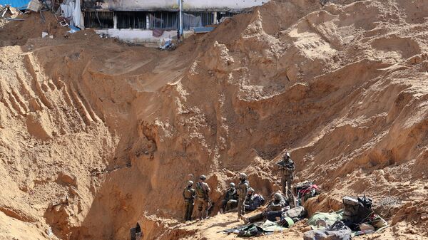 --PHOTO TAKEN DURING A CONTROLLED TOUR AND SUBSEQUENTLY EDITED UNDER THE SUPERVISION OF THE ISRAELI MILITARY-- This picture taken during a media tour organized by the Israeli military on February 8, 2024, shows Israeli soldiers at the entrance of a tunnel outside the compound of the United Nations Relief and Works Agency for Palestine Refugees (UNRWA) in Gaza City. - Sputnik International