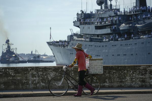 A street vendor walks his bicycle by the Russian vessel Smolny.  - Sputnik International