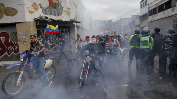 Protesters demonstrating against the official election results declaring President Nicolas Maduro's reelection ride through tear gas fired by police the day after the vote in Caracas, Venezuela, Monday, July 29, 2024. (AP Photo/Cristian Hernandez) - Sputnik International