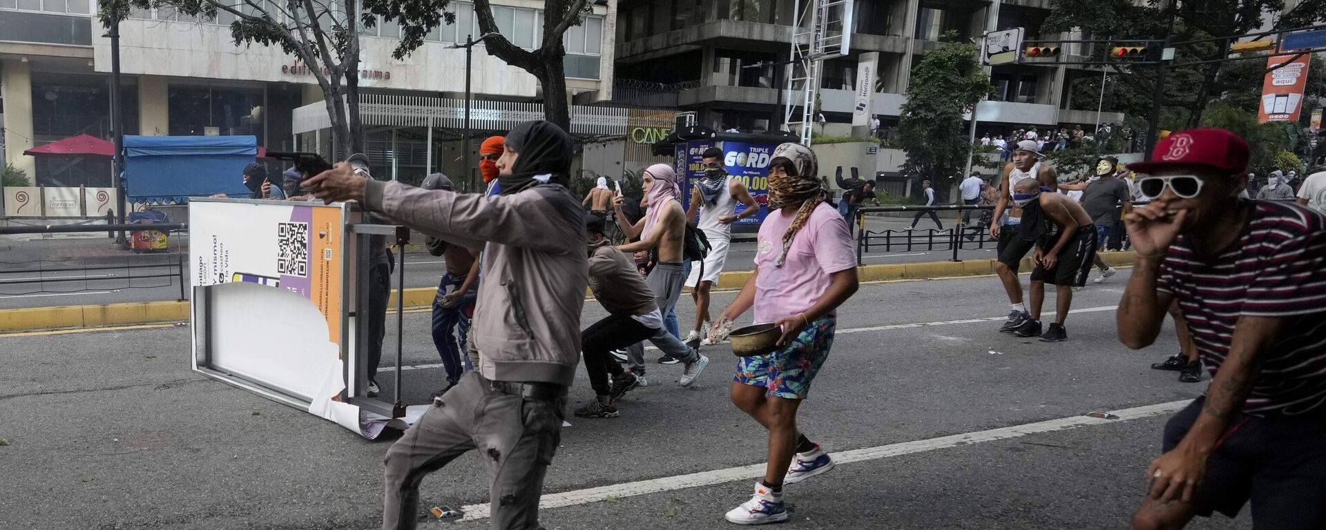 A protester aims a weapon during clashes with police amid demonstrations against the official election results declaring President Nicolas Maduro's reelection in Caracas, Venezuela, Monday, July 29, 2024, the day after the vote. (AP Photo/Fernando Vergara) - Sputnik International, 1920, 30.07.2024