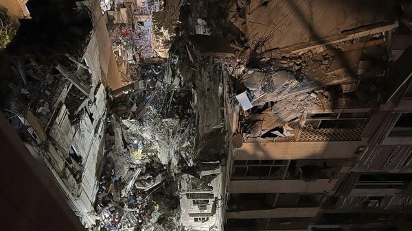 Civil defence workers and citizens gather near a destroyed building that was hit by an Israeli airstrike in the southern suburbs of Beirut, Lebanon, Tuesday, July 30, 2024. - Sputnik International