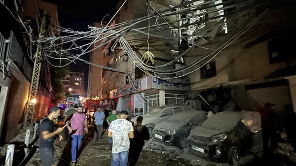 People gather near a destroyed building that was hit by an Israeli airstrike, Tuesday, July 30, 2024. - Sputnik International