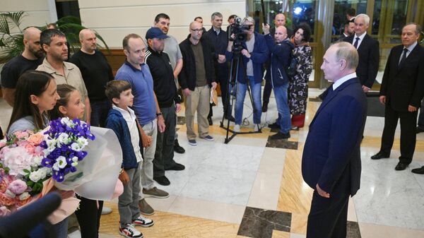 Russian President Vladimir Putin meets Russian citizens released after the Russian-US prisoner swap in Turkiye at Vnukovo International Airport in Moscow, Russia. - Sputnik International