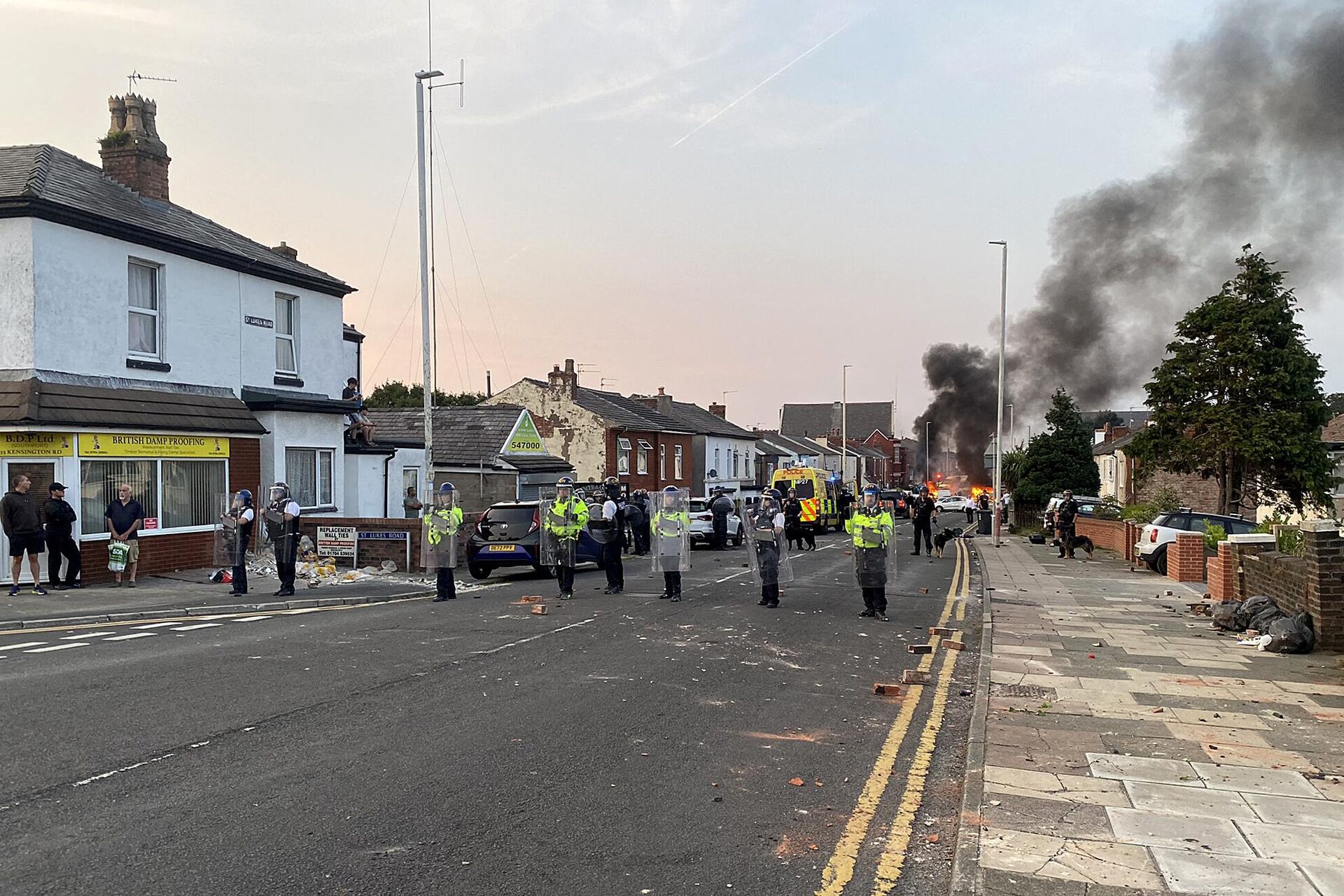 Smoke billows from a fire started by protesters as riot police stand guard after disturbances near the Southport Islamic Society Mosque in Southport, northwest England, on July 30, 2024, a day after a deadly child knife attack. - Sputnik International, 1920, 03.08.2024