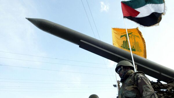 Lebanese Shiite Hezbollah militants parade with a missile as the Palestinian (R) and the movement's (back) flags flutter during an annual parade in the southern city of Nabatiyeh. File photo. - Sputnik International