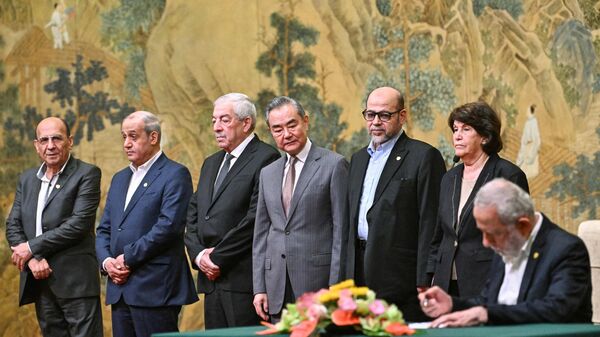 China's Foreign Minister Wang Yi (C) looks on during the signing of the Beijing declaration at the Diaoyutai State Guesthouse in Beijing on July 23, 2024. China's Foreign Minister Wang Yi on July 23 hailed an agreement by 14 Palestinian factions to set up an interim national reconciliation government to govern Gaza after the war. Palestinian factions including Hamas and Fatah met in Beijing this week in a renewed bid for reconciliation. (Photo by Pedro PARDO / POOL / AFP) - Sputnik International