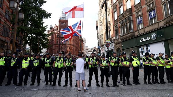 Police officers form a line in front of counter protesters in Nottingham, central England, on August 3, 2024 against the 'Enough is Enough' demonstration held in reaction to the fatal stabbings in Southport on July 29. UK police prepared for planned far-right protests and other demonstrations this weekend, after two nights of unrest in several English towns and cities following a mass stabbing that killed three young girls. (Photo by Darren Staples / AFP) - Sputnik International