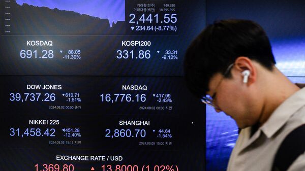 A man walks past a monitor displaying the benchmark Kospi index after the close of trading in Seoul on August 5, 2024.  - Sputnik International