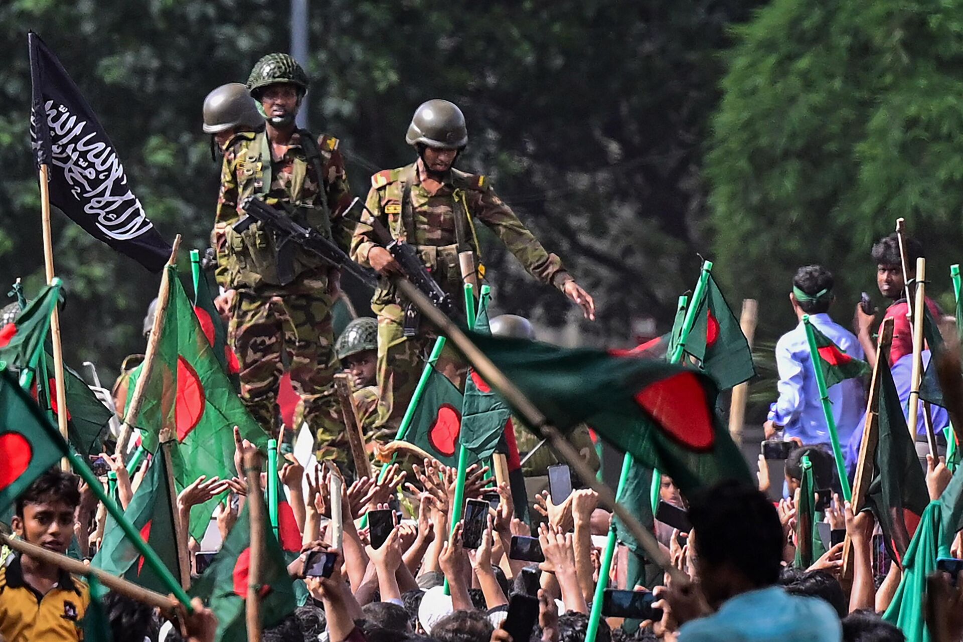 Anti-government protestors march towards Prime Minister Sheikh Hasina's palace as army personnel (C) stand guard in Shahbag area, near Dhaka university in Dhaka on August 5, 2024. - Sputnik International, 1920, 05.08.2024