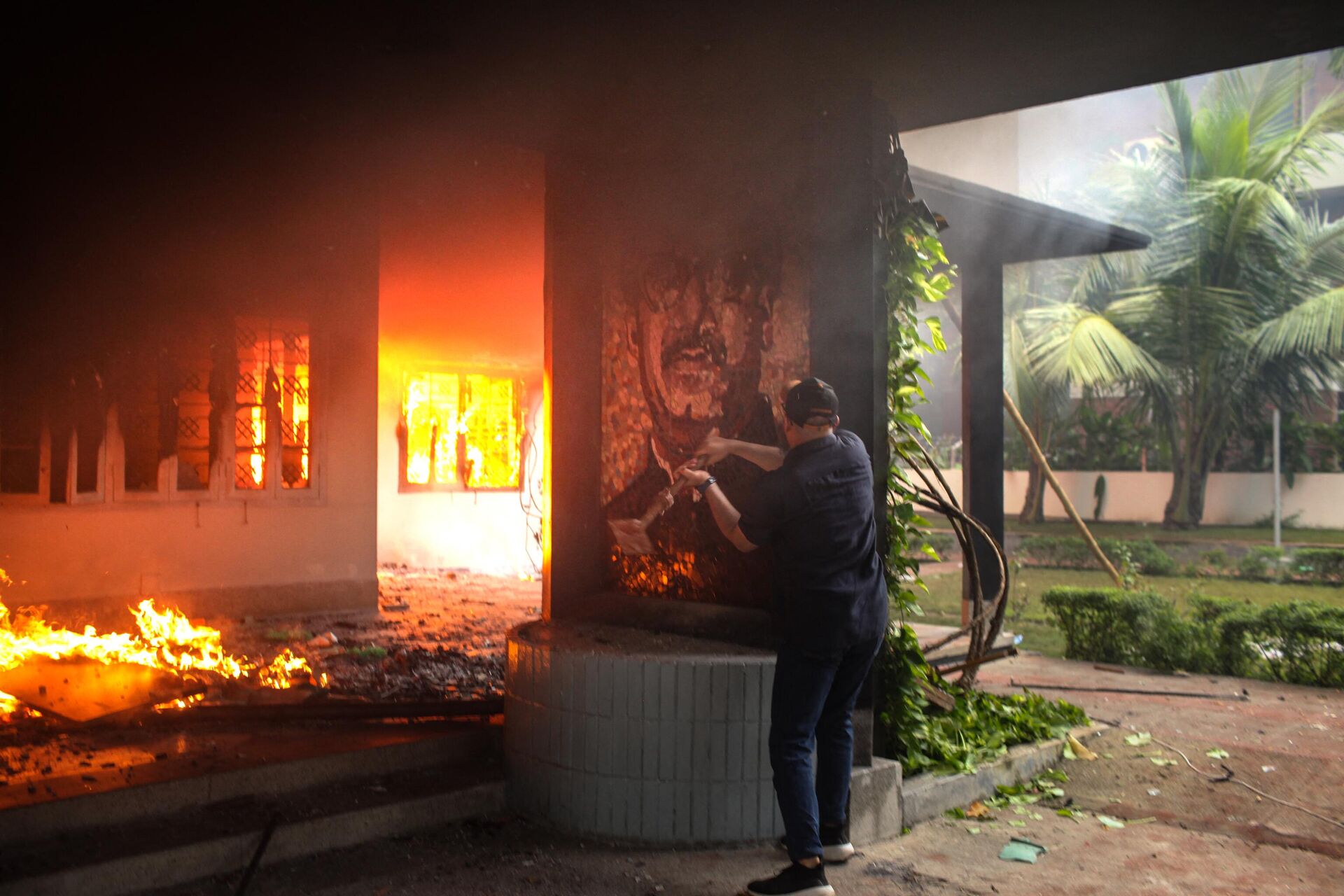 An anti-government protestor vandalises a portrait of Bangladesh's founding father Sheikh Mujibur Rahman as others set the Bangabandhu Memorial Museum on fire in Dhaka on August 5, 2024. - Sputnik International, 1920, 05.08.2024