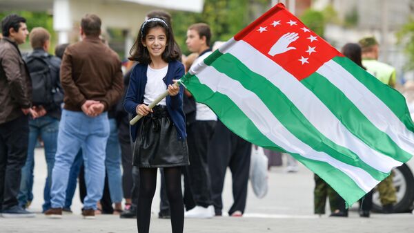 A girl holds the Abkhazian flag during celebrations of the Victory Day and the Independence Day of Abkhazia in Sukhum, Republic of Abkhazia. - Sputnik International