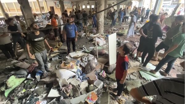 In this image made from a video, people inspect the dome at a school after being hit by an Israeli airstrike in Gaza City Saturday, Aug. 10, 2024. (AP Photo) - Sputnik International