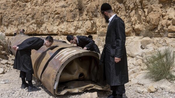 Ultra-Orthodox Jews observe the part of the intercepted ballistic missile that fell in the desert near the city of Arad, Israel, Sunday, April 28, 2024.  - Sputnik International