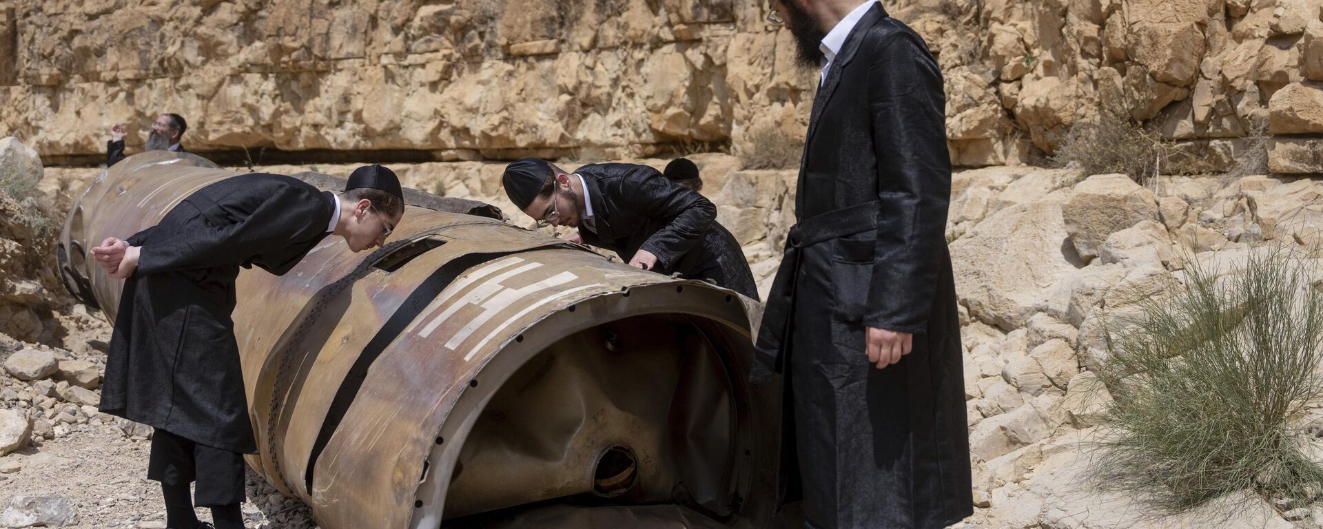 Ultra-Orthodox Jews observe the part of the intercepted ballistic missile that fell in the desert near the city of Arad, Israel, Sunday, April 28, 2024.  - Sputnik International, 1920, 11.08.2024