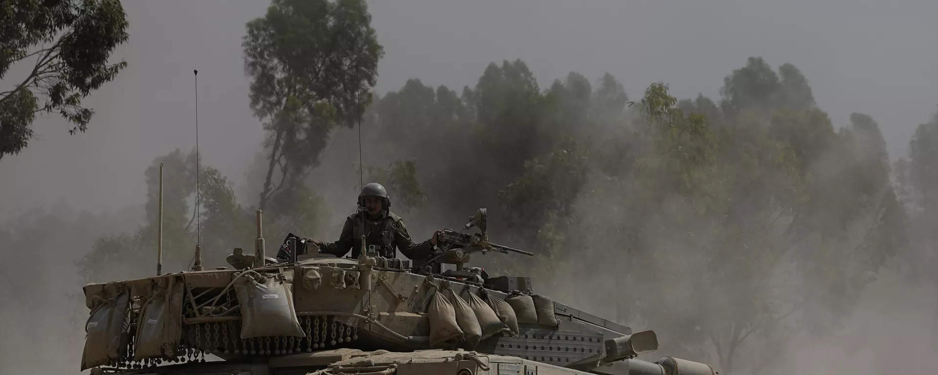 An Israeli soldier moves on the top of a tank near the Israeli-Gaza border, as seen from southern Israel, Wednesday, July 24, 2024.  - Sputnik International, 1920, 06.10.2024