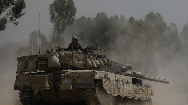 An Israeli soldier moves on the top of a tank near the Israeli-Gaza border, as seen from southern Israel, Wednesday, July 24, 2024.  - Sputnik International