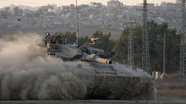 With destroyed buildings in the Gaza Strip behind him, an Israeli soldier waves from a tank, near the Israel-Gaza border in southern Israel, Thursday, Aug. 1, 2024.  - Sputnik International