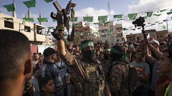 A member of Hamas' military wing raises a rifle seized from Israeli security forces during an arms show for the group at Nusseirat refugee camp, central Gaza Strip, Friday, June 30, 2023 - Sputnik International