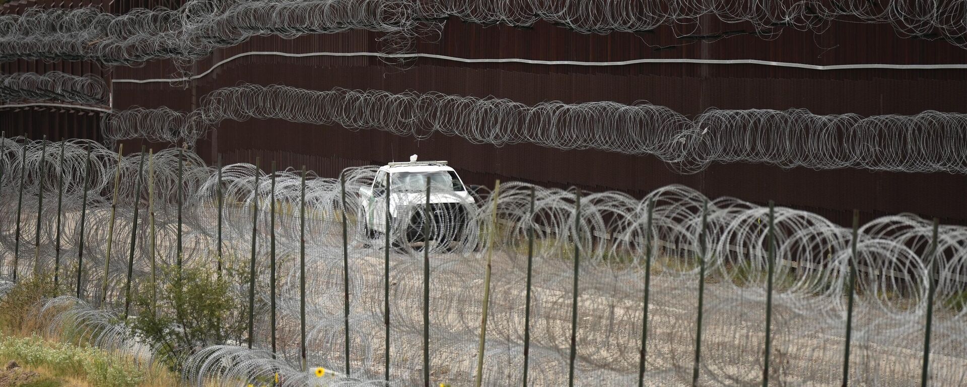 A vehicle drives along the U.S. side of the US-Mexico border wall in Nogales, Ariz. on Tuesday, June 25, 2024. - Sputnik International, 1920, 18.08.2024