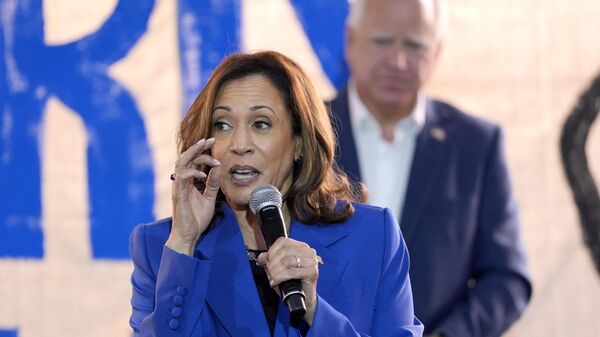 Democratic presidential nominee Vice President Kamala Harris speaks as Democratic vice presidential nominee Minnesota Gov. Tim Walz listens at a campaign event, Sunday, Aug. 18, 2024, in Rochester, Pa. - Sputnik International