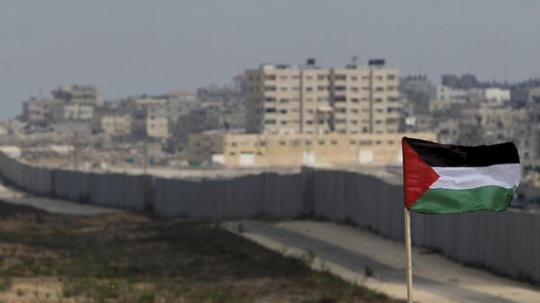 FILE - A Palestinian flag is seen with the background of a section of the wall in the Philadelphi corridor between Egypt and Gaza, on the background, near the southern Gaza Strip town of Rafah. - Sputnik International