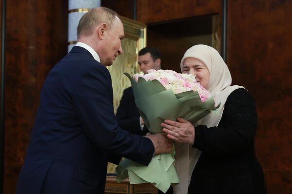 Vladimir Putin informally meets with Ramzan Kadyrov&#x27;s mother, Aimani Kadyrova, and presents her with a bouquet of flowers. - Sputnik International