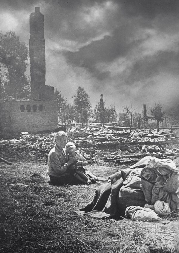 On September 21, 1943, troops of the 136th Rifle Division of the Voronezh Front liberated the town of Baryshevka in the Kiev region. A local survivor and her child sit among the ashes of her home destroyed by the Germans during their retreat. - Sputnik International